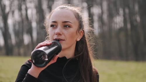Woman Drinking Water from Bottle Outdoors