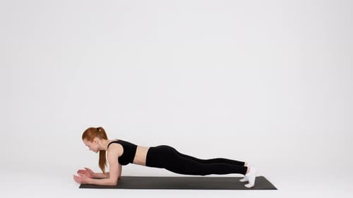 Woman Doing Forearm Plank Exercise on Yoga Mat