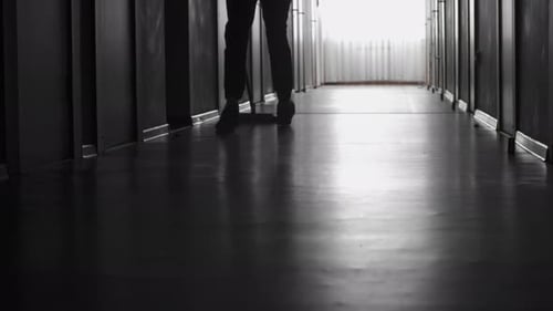 Person Mopping Hallway in Dark Environment