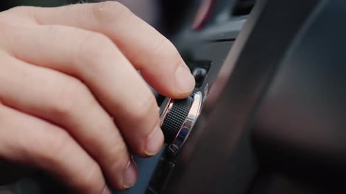 La mano masculina ajusta la sintonización de la radio del coche