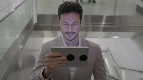 Man Using Tablet on Escalator