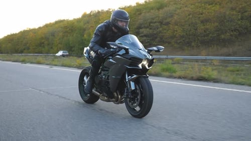 Young Man in Helmet Riding Fast on Modern Sport Motorbike at Highway. Motorcyclist Racing
