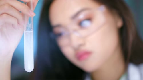 Young Adult Researcher Examining Test Tube Liquid