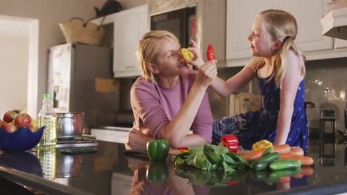 Side view of Caucasian woman cooking with her daughter at home