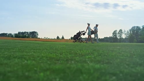Golf Players Walk Field on Course
