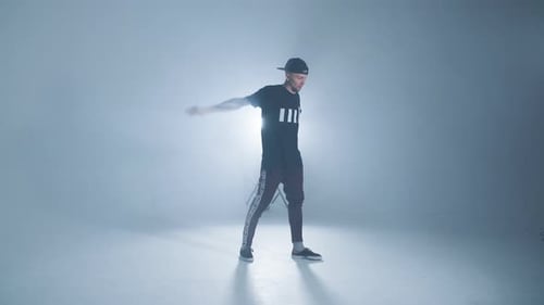 Sporty Modern Style Hip-hop Dancer Shows His Dance on Blue Studio Background