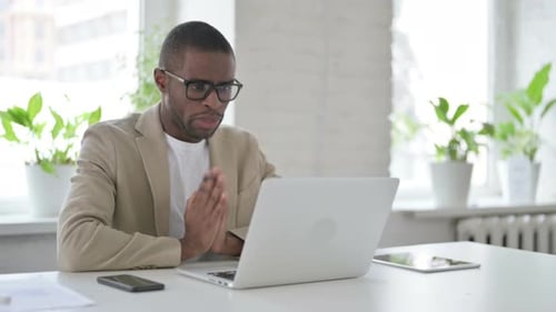 African Man Talking on Video Call on Laptop in Office