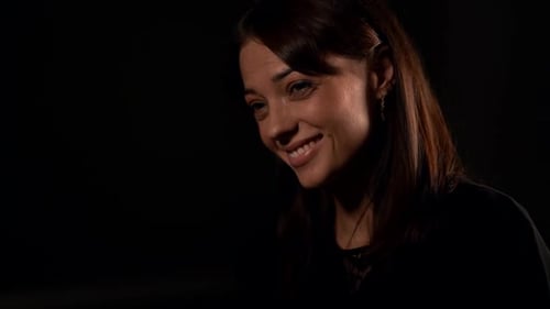 Mulher morena emocional está sorrindo e rindo com interlocutor, retrato