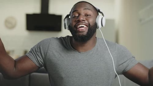 Man Dancing and Singing with Headphones at Home
