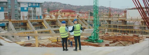 Engineers Review Construction Plans at Construction Site