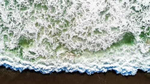 Aerial View of Waves Crashing on Beach