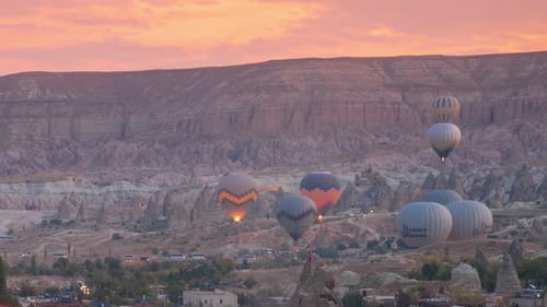 Colorful hot air balloons flying over the valley at sunrise time Goreme, Cappadocia, Turkey