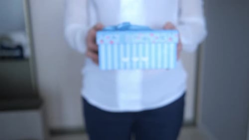 Woman Holds Out Beautiful Striped Birthday Gift