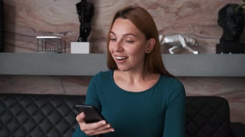 Woman Reacts Happily to News on Phone