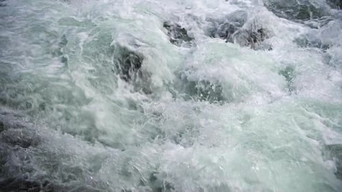 Close up of river stones with flowing water, clean water flowing in a mountain river