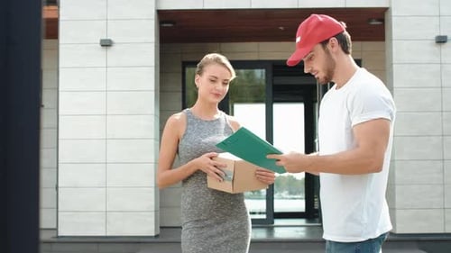 Delivery Man Hands Package to Woman at House