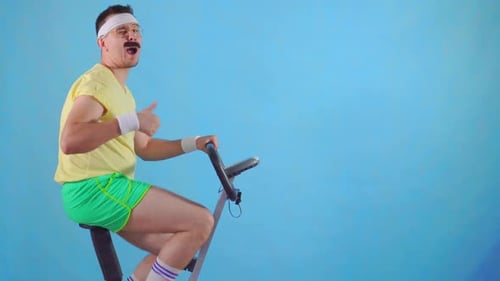 Man on Exercise Bike Gives Thumbs Up