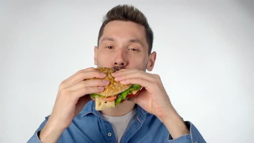 Man with Beard Eating a Large Hamburger