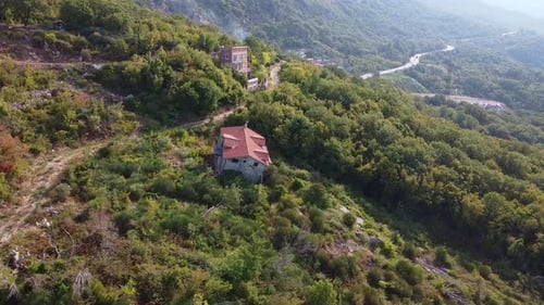 Aerial View of Ruined Building with Red Roof in the Mountain