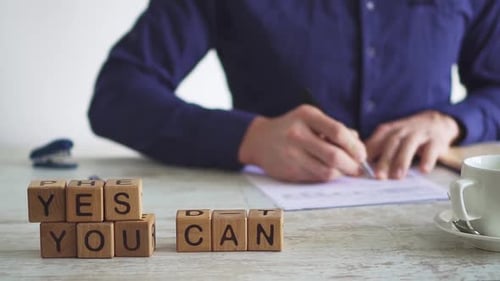 Inspirational Message With Wooden Blocks and Person Writing
