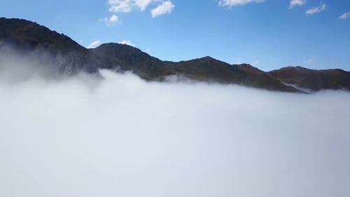 Peak of Foggy Green Mountains and Cloudscape under Blue Sky