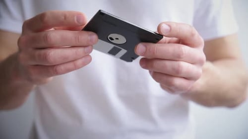 Man holds floppy disk in hands
