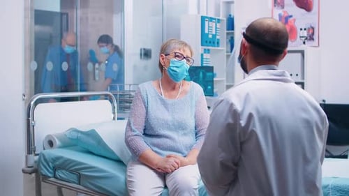 Doctor Consults with Senior Patient in Hospital Room