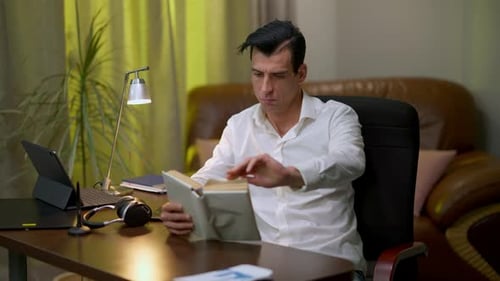 Absorbed Concentrated Middle Eastern Man Reading Professional Literature Sitting in Home Office