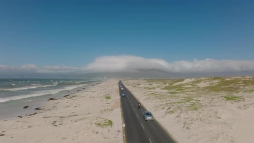 Aerial View of Traffic on Road Leading Through Sand Field Along Sea Coast