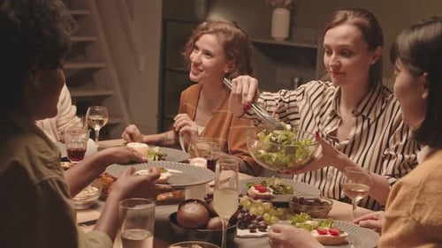 Young Woman Serving Salad to Friends