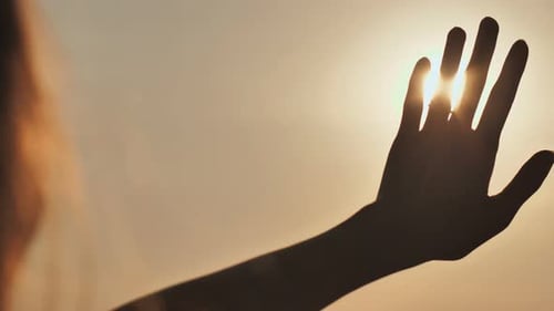 Das Mädchen berührt den Sonnenuntergang Sonne die Finger