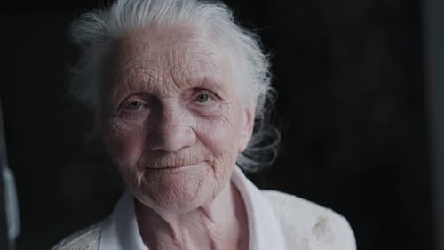 Retrato de abuela canosa con rostro arrugado que habla fácilmente ante la cámara