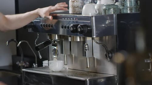 Tattooed Male Barista Making Americano on Coffee Machine