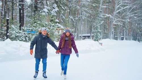 Couple Ice Skating Together in Winter Wonderland