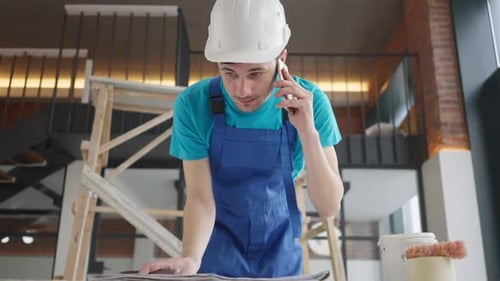 Un constructeur stressé et anxieux se dispute au téléphone avec un entrepreneur