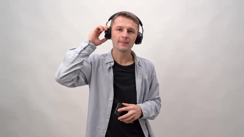 Young Man Listens to Music in Headphones