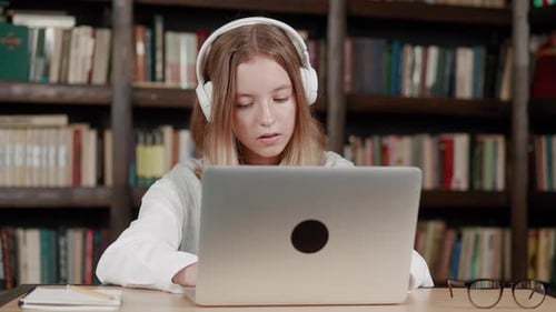 Library Gifted Girl Uses Laptop Writes Notes for the Paper Essay Study for Class Assignment