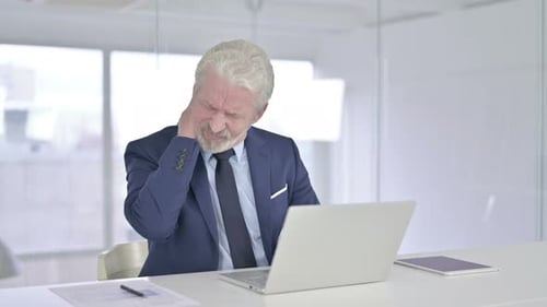 Senior Businessman Suffering Neck Pain at Office Desk