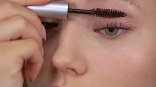 Woman Applying Mascara to Lashes in Close Up Shot