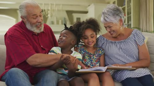 Grandparents Reading with Grandchildren in Cozy Home