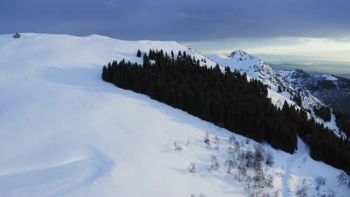 Top Aerial View of Snow Capped Mountain During the Afternoon at the Beginning of Winter Season. Dark