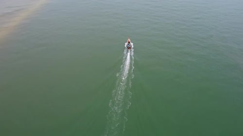 Aerial view from a drone of Thai traditional longtail fishing boats sailing in the sea.