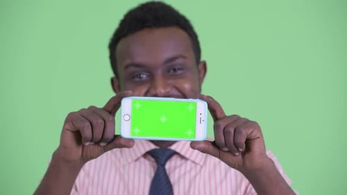 Young Adult Holding Smartphone with Green Screen