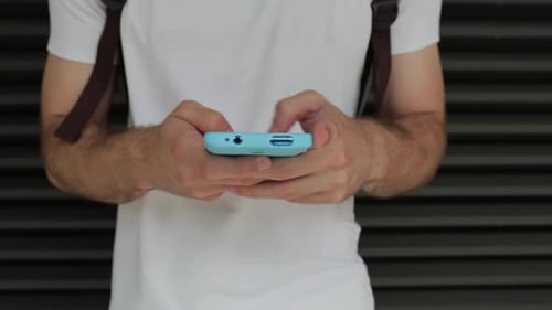 Close Up Young Hispanic Man Using a Mobile Phone Outdoor