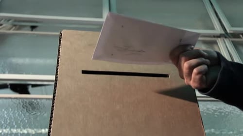 Urne avec personne qui vote sur bulletin de vote vierge. Version 4K.