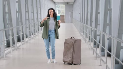 Happy Contented Hispanic Young Girl Traveler Tourist Woman Standing at Airport with Suitcase Shows
