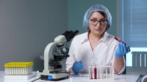 Woman Examining Blood Sample in Science Laboratory