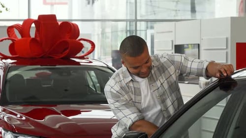 Young Man Buys New Car at Dealership