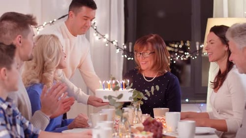 Family Celebrates Birthday Party at Night with Cake
