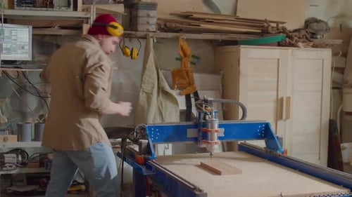 Woodworker Operating CNC Machine with Computer